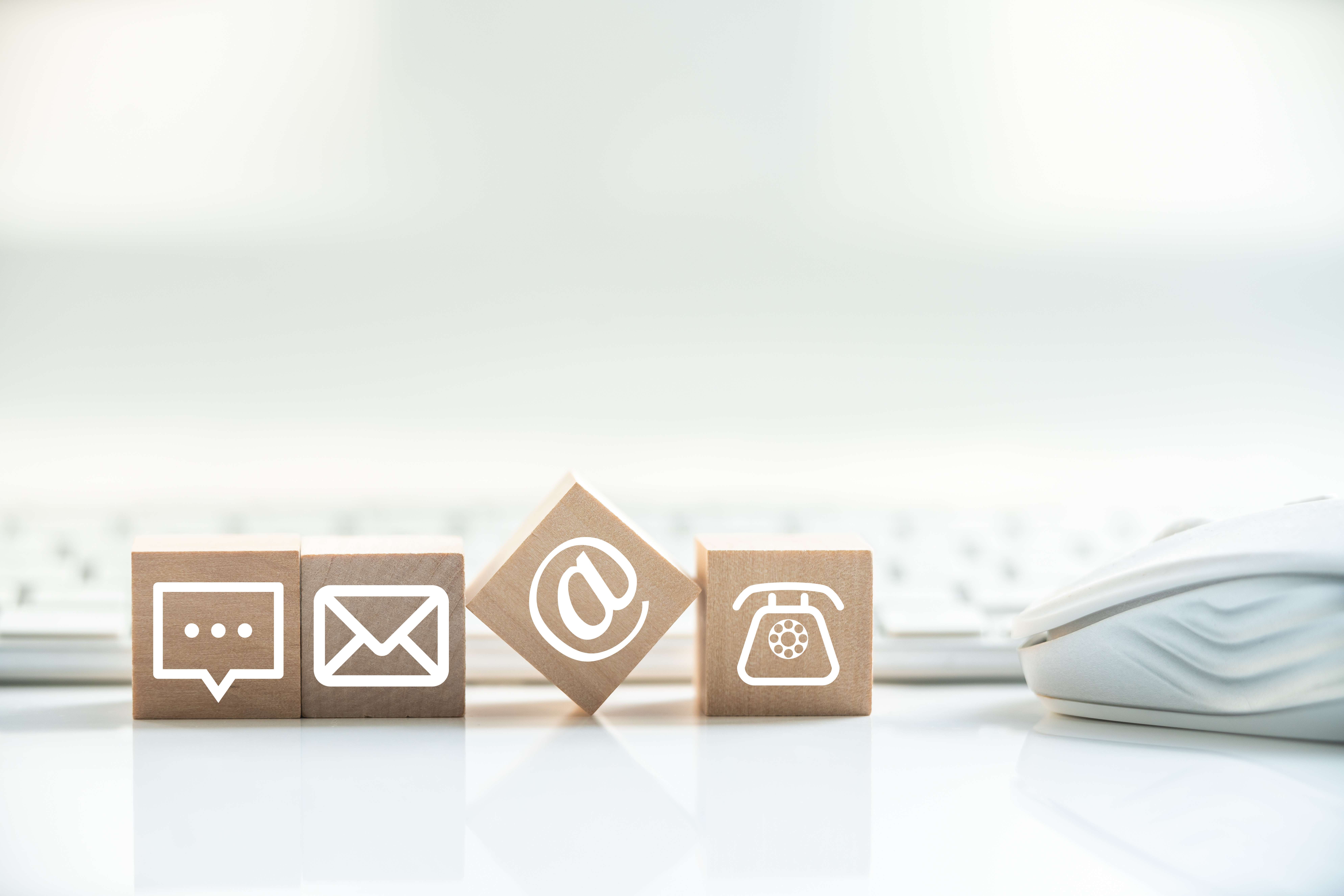 Kontakt-Symbole auf Holzwürfeln – Nachricht, E-Mail und Telefon